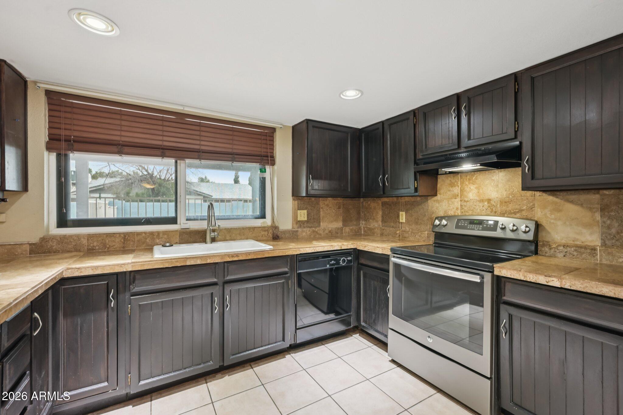 2201 West Utopia Road Phoenix, AZ 85027 - Photo 22 of 50 a kitchen with a sink stove and cabinets