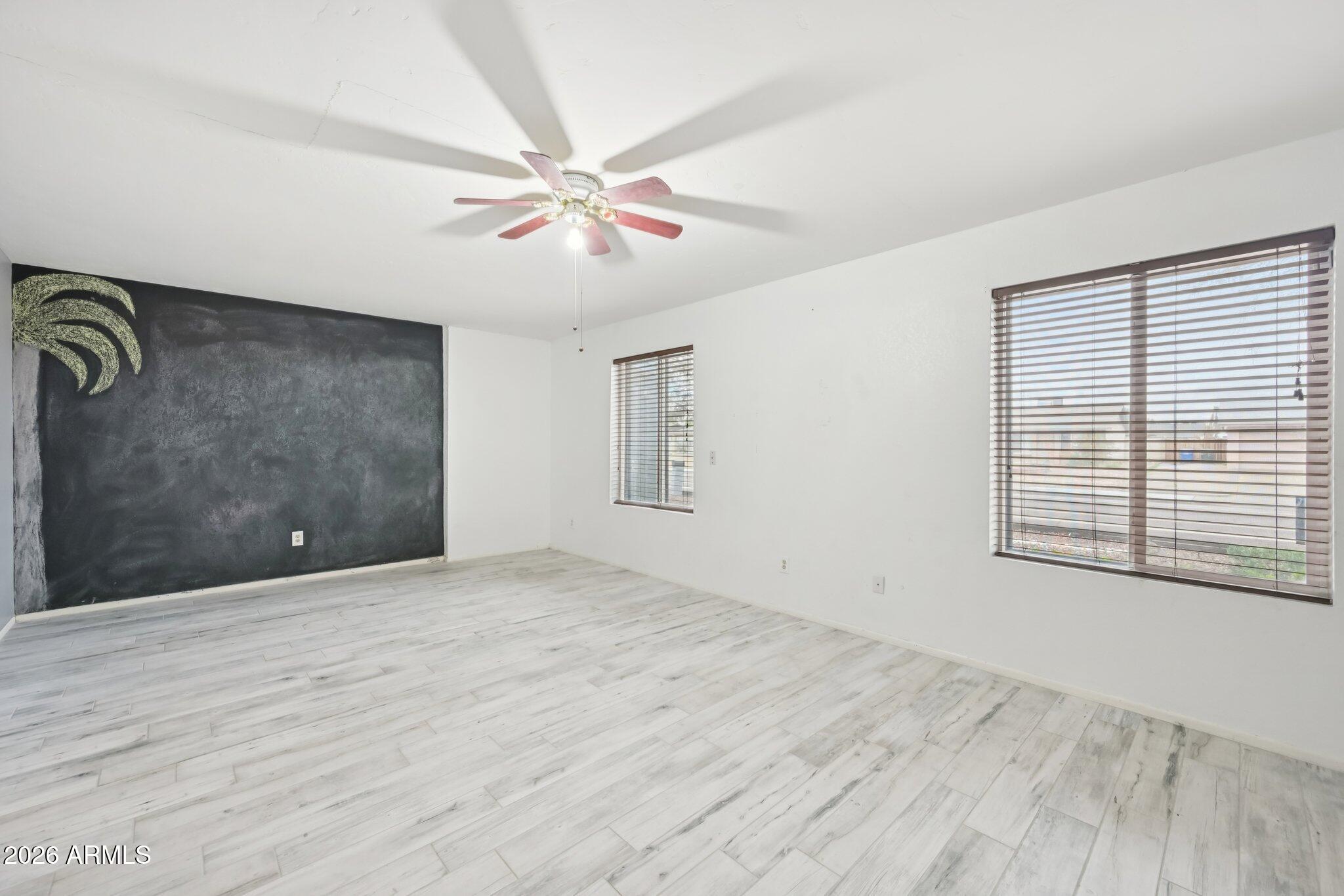 2201 West Utopia Road Phoenix, AZ 85027 - Photo 25 of 50 a view of an empty room with chandelier fan and wooden floor