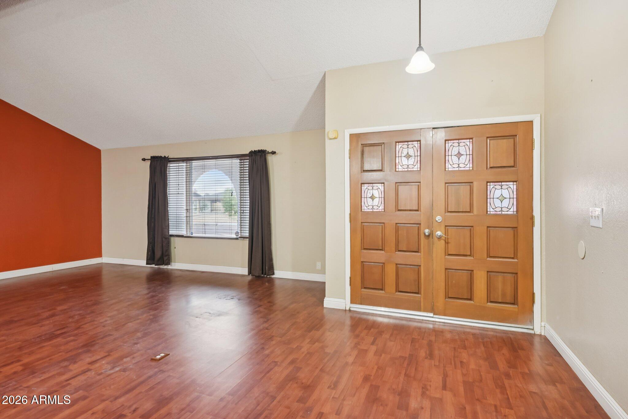 2201 West Utopia Road Phoenix, AZ 85027 - Photo 5 of 50 a view of an empty room with wooden floor and a window