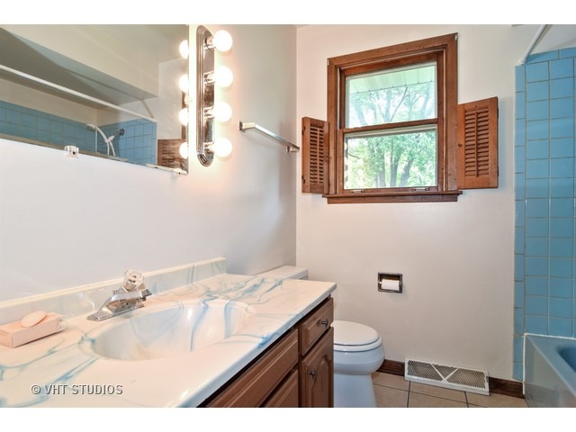 21 West 702 Lydia Road Addison, IL 60101 - Photo 7 of 10 a bathroom with a granite countertop sink a toilet and a mirror