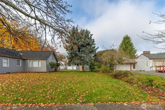 a view of a house with a big yard and large trees