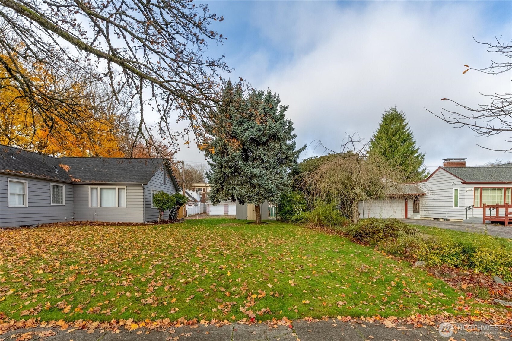 a view of a house with a big yard and large trees