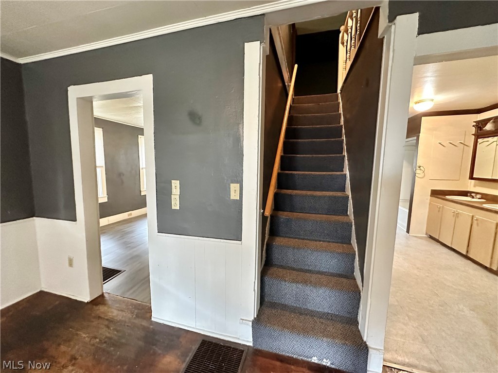 6841 Warren - Sharon Road Brookfield, OH 44403 - Photo 14 of 32 Stairs with sink, crown molding, and wood-type flooring