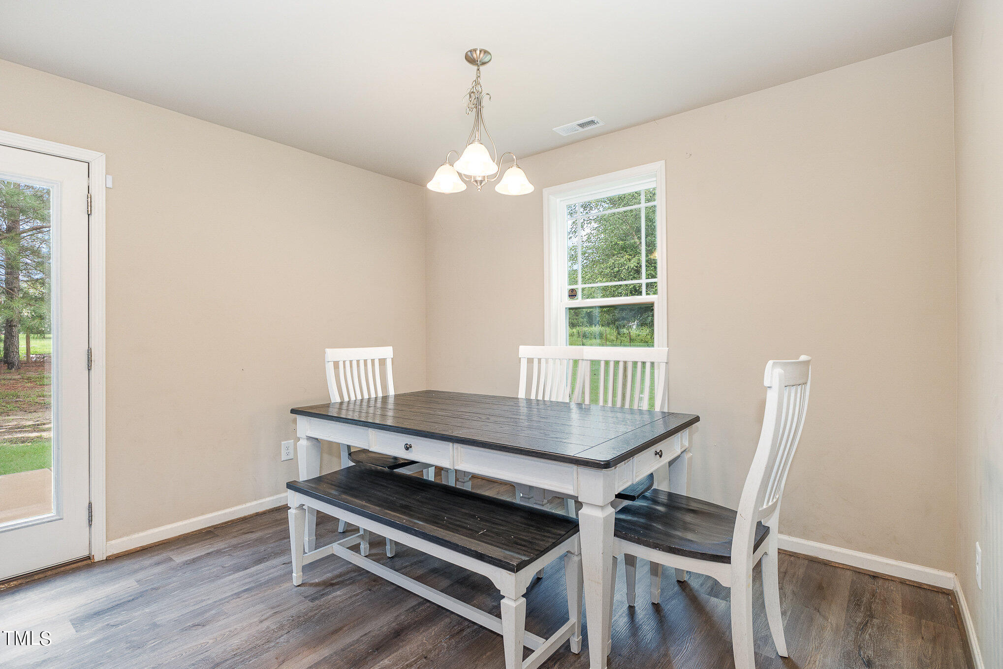 6005 Zacks Mill Road Angier, NC 27501 - Photo 7 of 23 a dining room with wooden floor a chandelier a wooden table and chairs