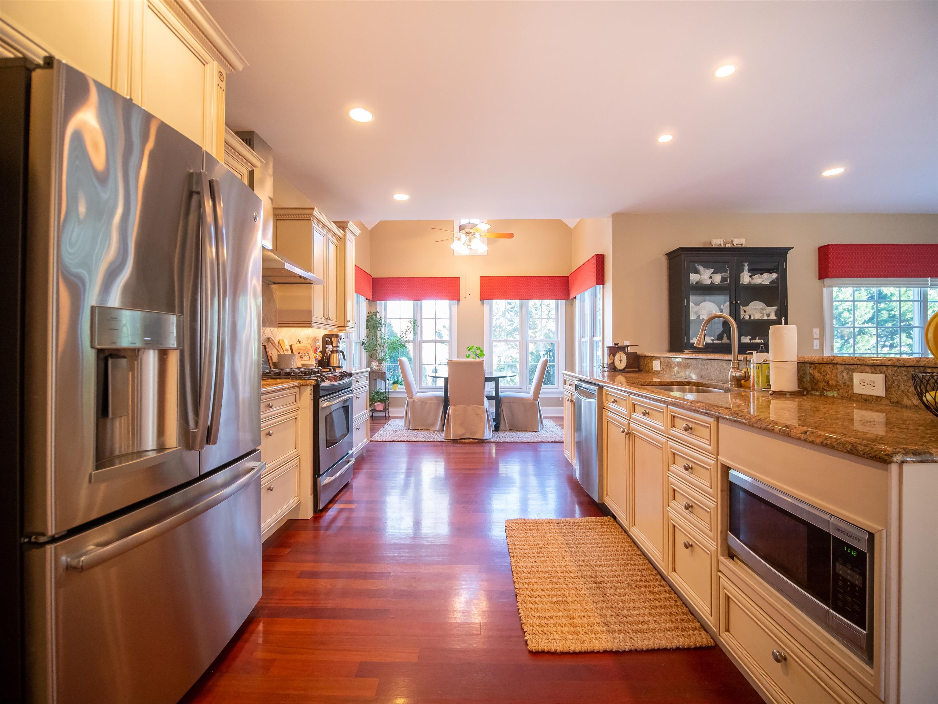 9 MGM Way Ocean View, NJ 08230 - Photo 14 of 61 a large kitchen with stainless steel appliances granite countertop a refrigerator a oven a island and couches with wooden floor