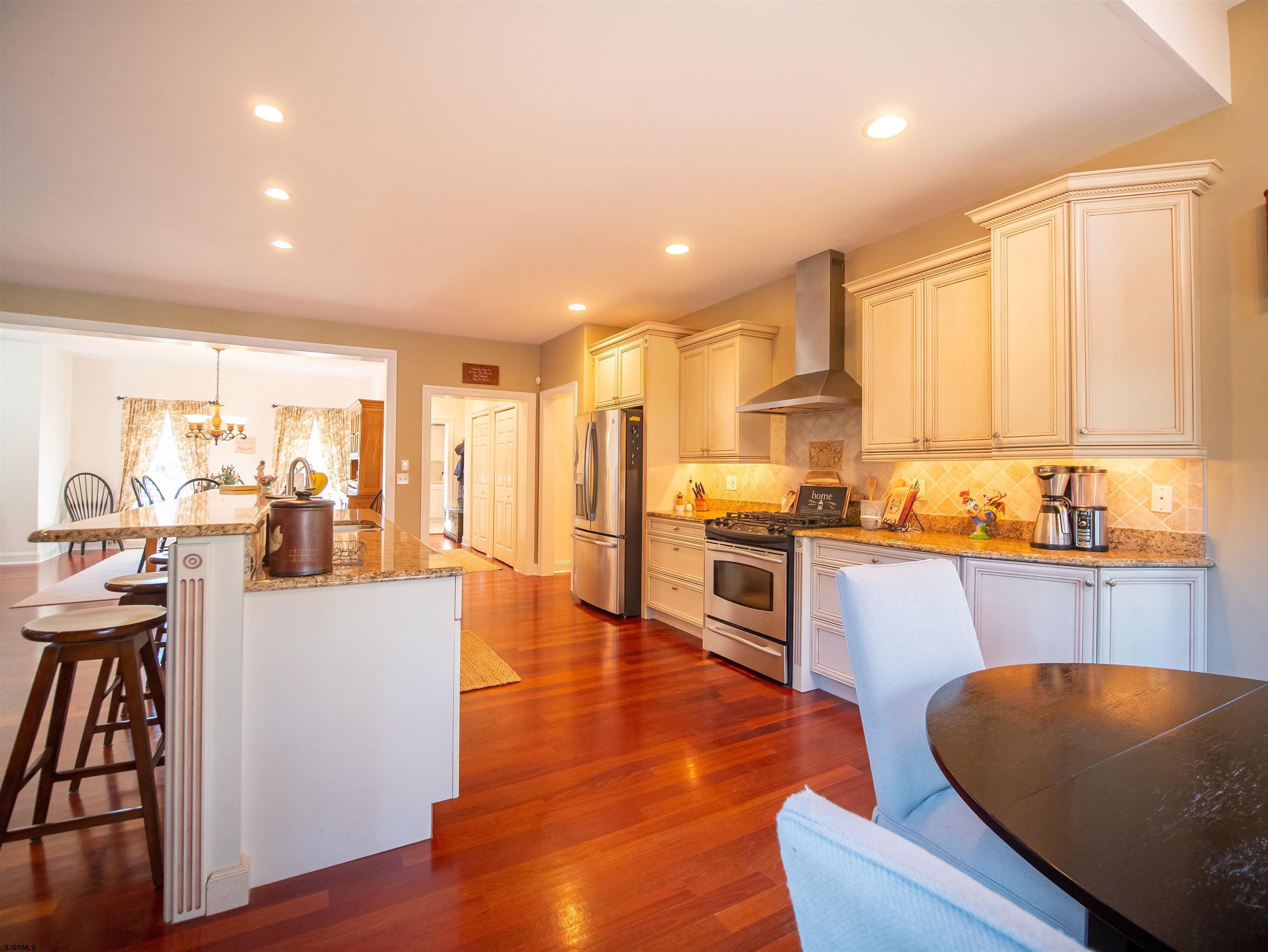 9 MGM Way Ocean View, NJ 08230 - Photo 18 of 61 a kitchen with stainless steel appliances granite countertop a refrigerator a sink dishwasher a stove and white cabinets with wooden floor