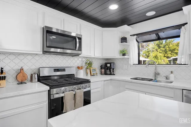 a kitchen with stainless steel appliances a stove sink microwave and cabinets
