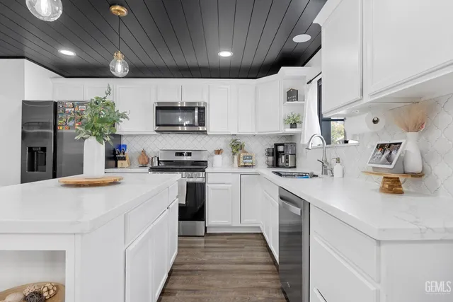 a kitchen with stainless steel appliances granite countertop a sink a stove and cabinets