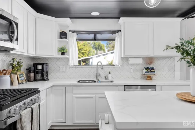 a kitchen with kitchen island white cabinets and white appliances