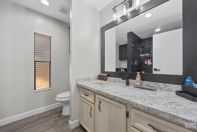 a bathroom with a granite countertop sink and a mirror