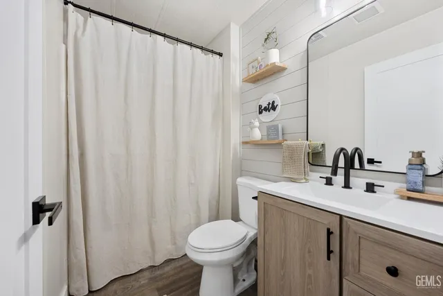 a bathroom with a sink a toilet and shower curtain