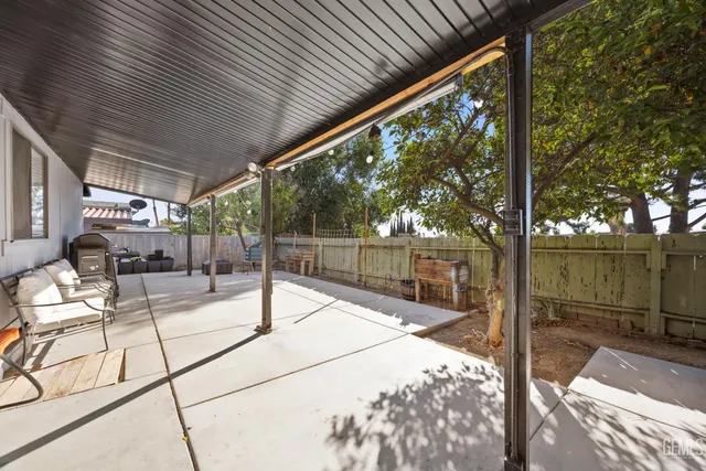 a view of a patio with a table chairs and wooden fence