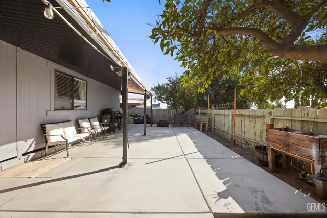 a view of a patio with table and chairs with wooden floor and fence