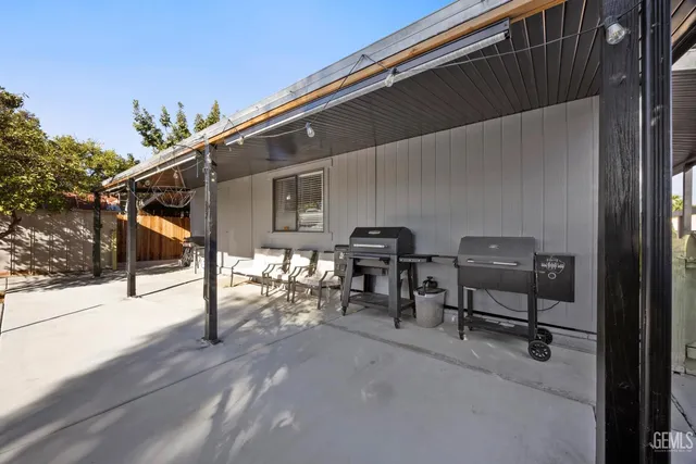a view of a patio with table and chairs with wooden floor and fence