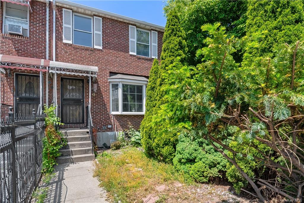 a front view of a house with a yard and potted plants