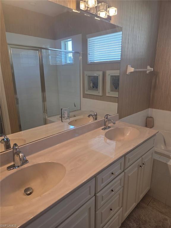 6719 Crowned Eagle Lane Naples, FL 34113 - Photo 15 of 23 a bathroom with a sink and a mirror