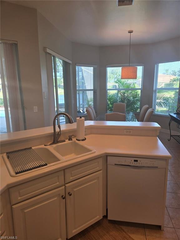 6719 Crowned Eagle Lane Naples, FL 34113 - Photo 21 of 23 a view of a kitchen counter top a sink and dishwasher with wooden floor