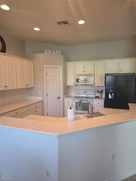 6719 Crowned Eagle Lane Naples, FL 34113 - Photo 9 of 23 a kitchen with stainless steel appliances granite countertop a sink and cabinets