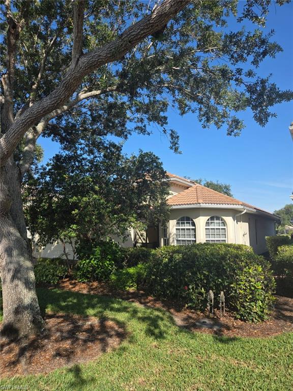 6719 Crowned Eagle Lane Naples, FL 34113 - Photo 10 of 23 a view of a house with a tree in the yard