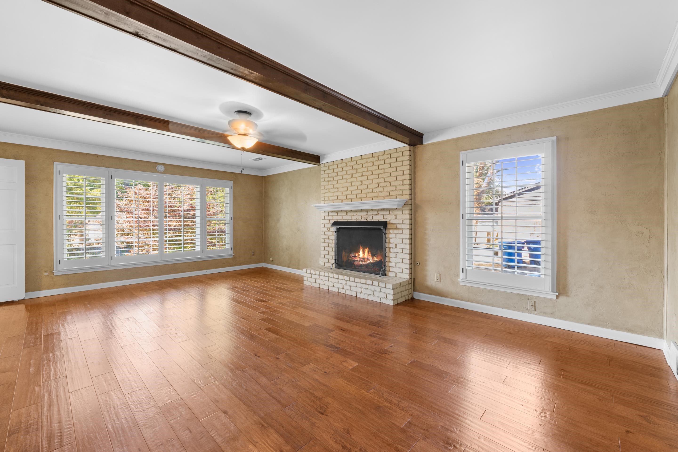 1751 Magnolia Tree Road Germantown, TN 38138 - Photo 16 of 36 an empty room with wooden floor fireplace and windows