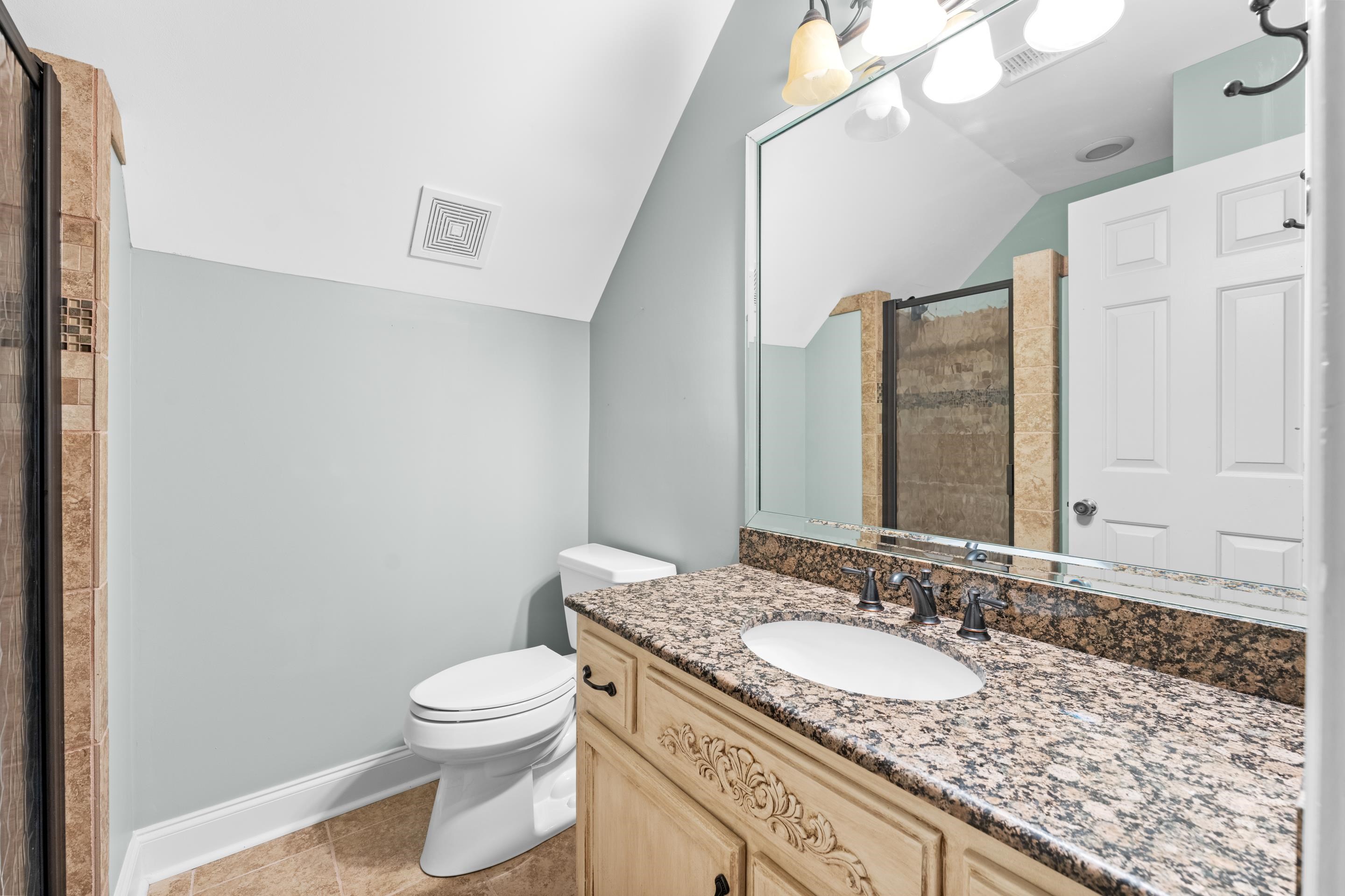 1751 Magnolia Tree Road Germantown, TN 38138 - Photo 30 of 36 a bathroom with a granite countertop sink a toilet and a mirror