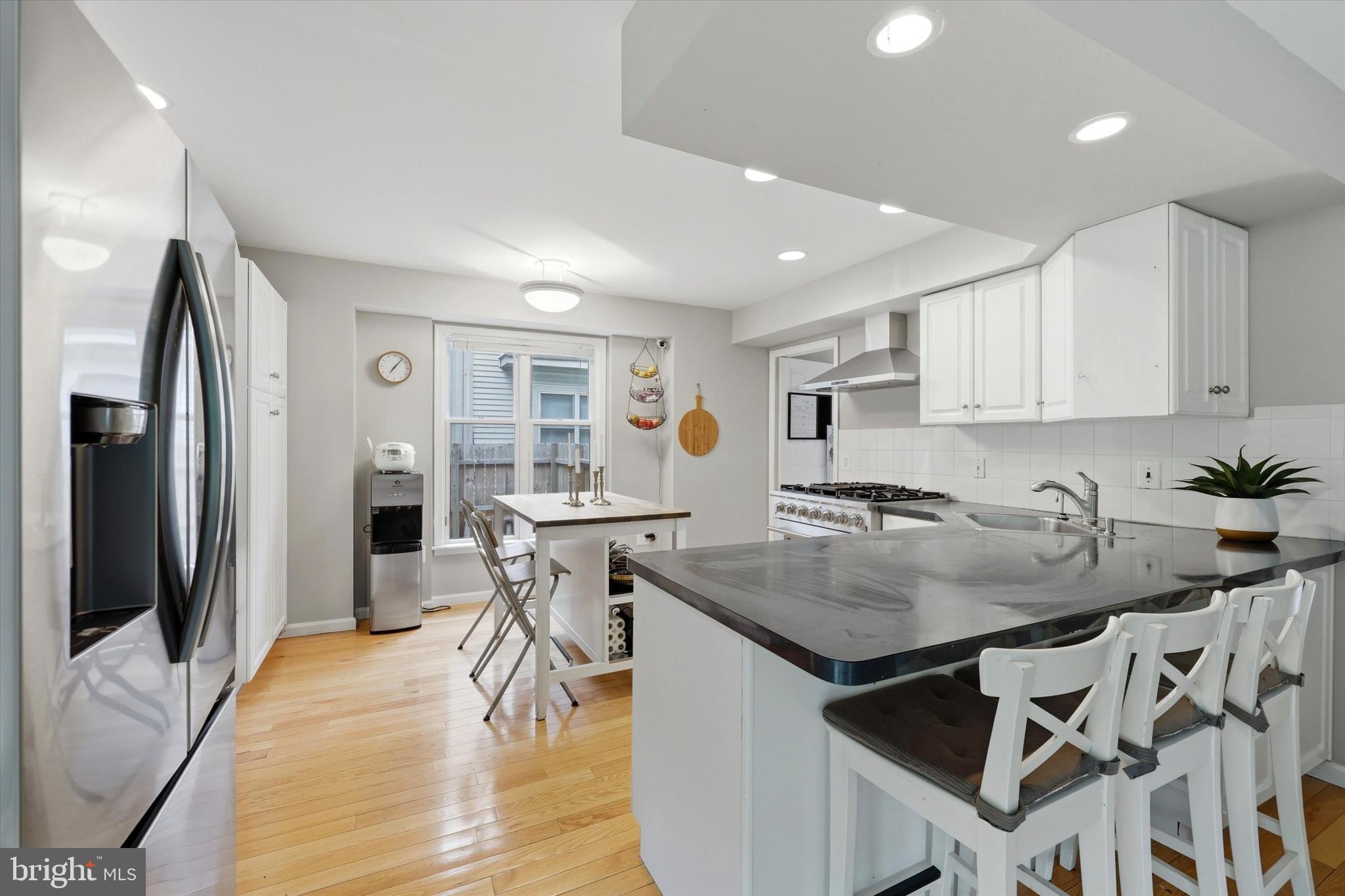 320 Maple Avenue Wyncote, PA 19095 - Photo 6 of 28 a kitchen with stainless steel appliances granite countertop a stove top oven a sink a refrigerator and white cabinets with wooden floor