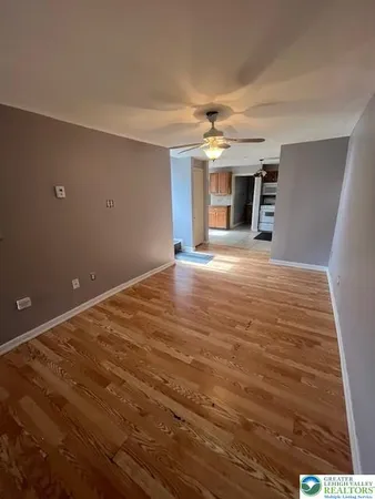 a view of an empty room with a fireplace and a window