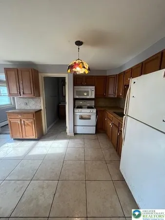 a kitchen with granite countertop a refrigerator and a stove top oven