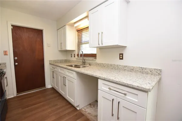 a kitchen with a sink cabinets and a window