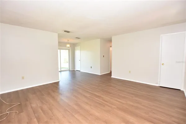 a view of an empty room with wooden floor