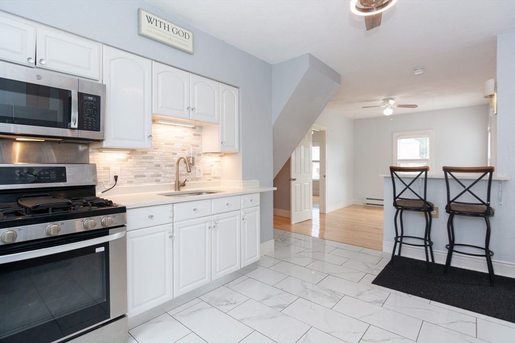 14 Russell Street Everett, MA 02149 - Photo 11 of 32 a kitchen with granite countertop a stove a sink and a microwave