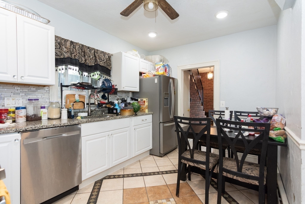 14 Russell Street Everett, MA 02149 - Photo 20 of 32 a kitchen with stainless steel appliances granite countertop a dining table chairs refrigerator and sink