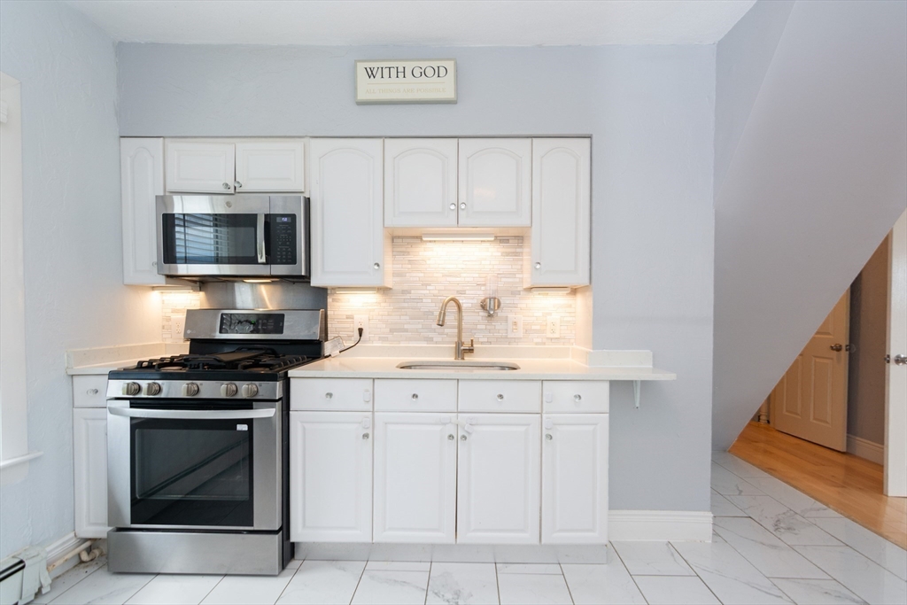 14 Russell Street Everett, MA 02149 - Photo 8 of 32 a kitchen with granite countertop white cabinets and stainless steel appliances