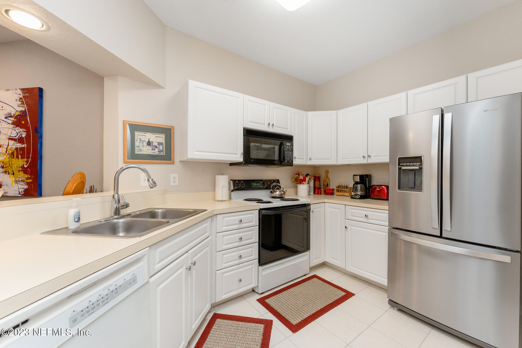 1321 Vista Cove Road St. Augustine, FL 32084 - Photo 4 of 27 a kitchen with stainless steel appliances granite countertop a refrigerator sink stove and white cabinets