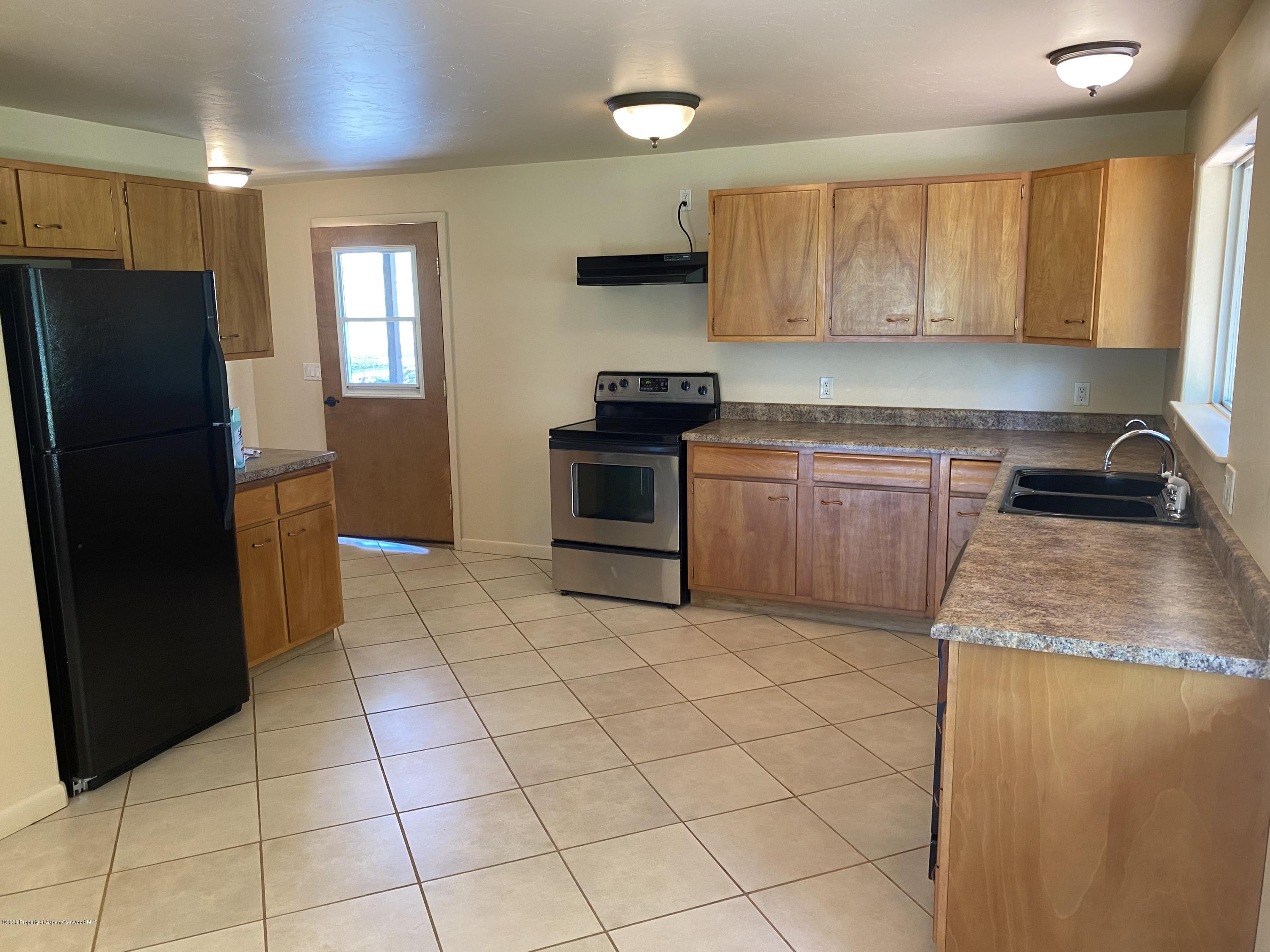 133 County Road 263 Silt, CO 81652 - Photo 7 of 16 a kitchen with granite countertop a refrigerator and a stove top oven