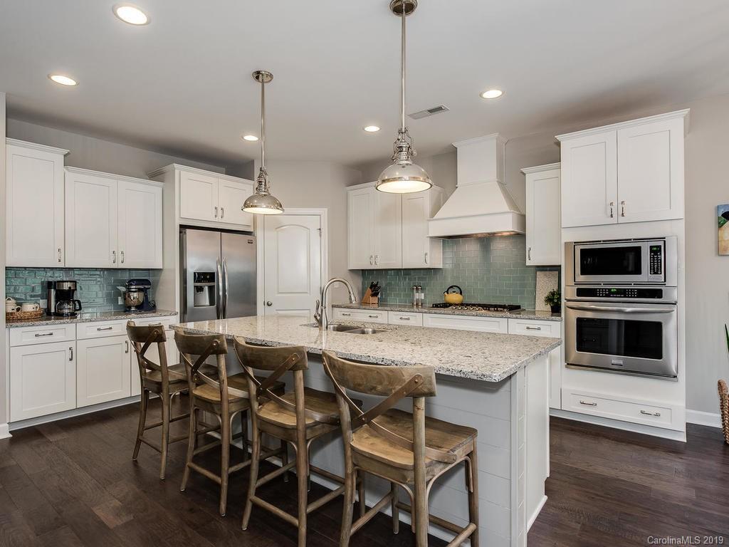 5390 Meadowcroft Way Fort Mill, SC 29708 - Photo 6 of 33 a kitchen with stainless steel appliances kitchen island granite countertop a table chairs sink and cabinets