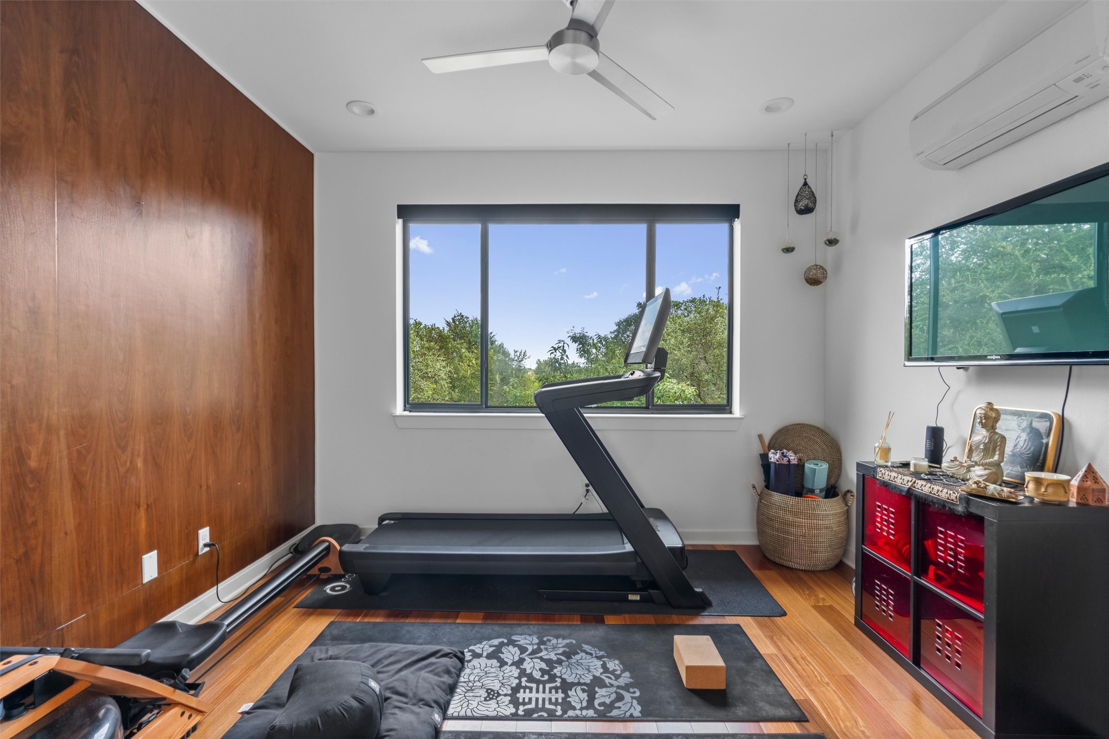 408 Starlight Village Loop Leander, TX 78641 - Photo 30 of 40 A dedicated exercise room, office, or guest bedroom features rich hardwood flooring and expansive windows framing vibrant outdoor greenery.
