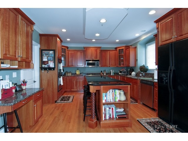 3-n943 Ralph Waldo Emerson Lane St. Charles, IL 60175 - Photo 4 of 24 a kitchen with stainless steel appliances granite countertop a refrigerator a sink dishwasher a stove and black cabinets with wooden floor