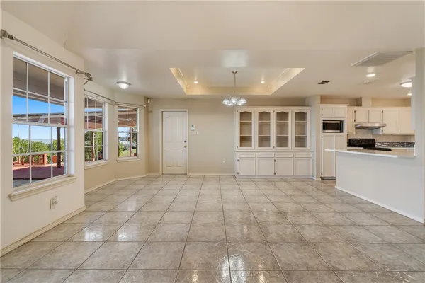 a view of an empty room with window and cabinet