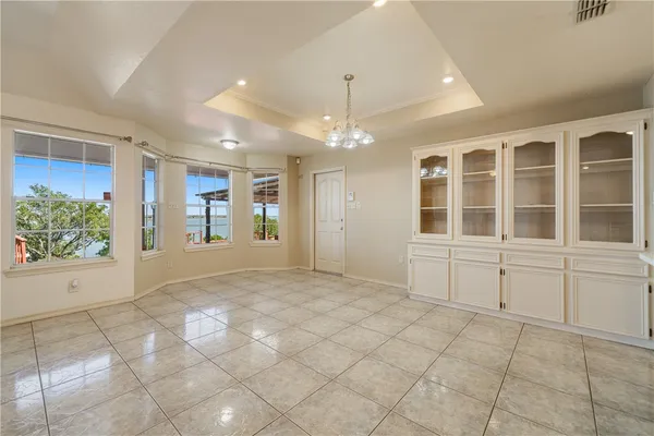 a view of a kitchen with kitchen island stainless steel appliances refrigerator a stove a sink dishwasher with a fireplace and a kitchen view