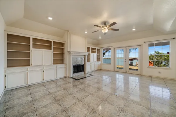 a view of a livingroom with a chandelier fan and kitchen view