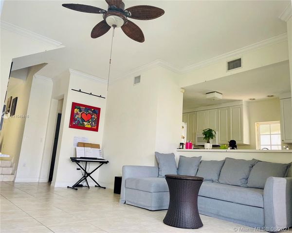 a living room with furniture and a ceiling fan