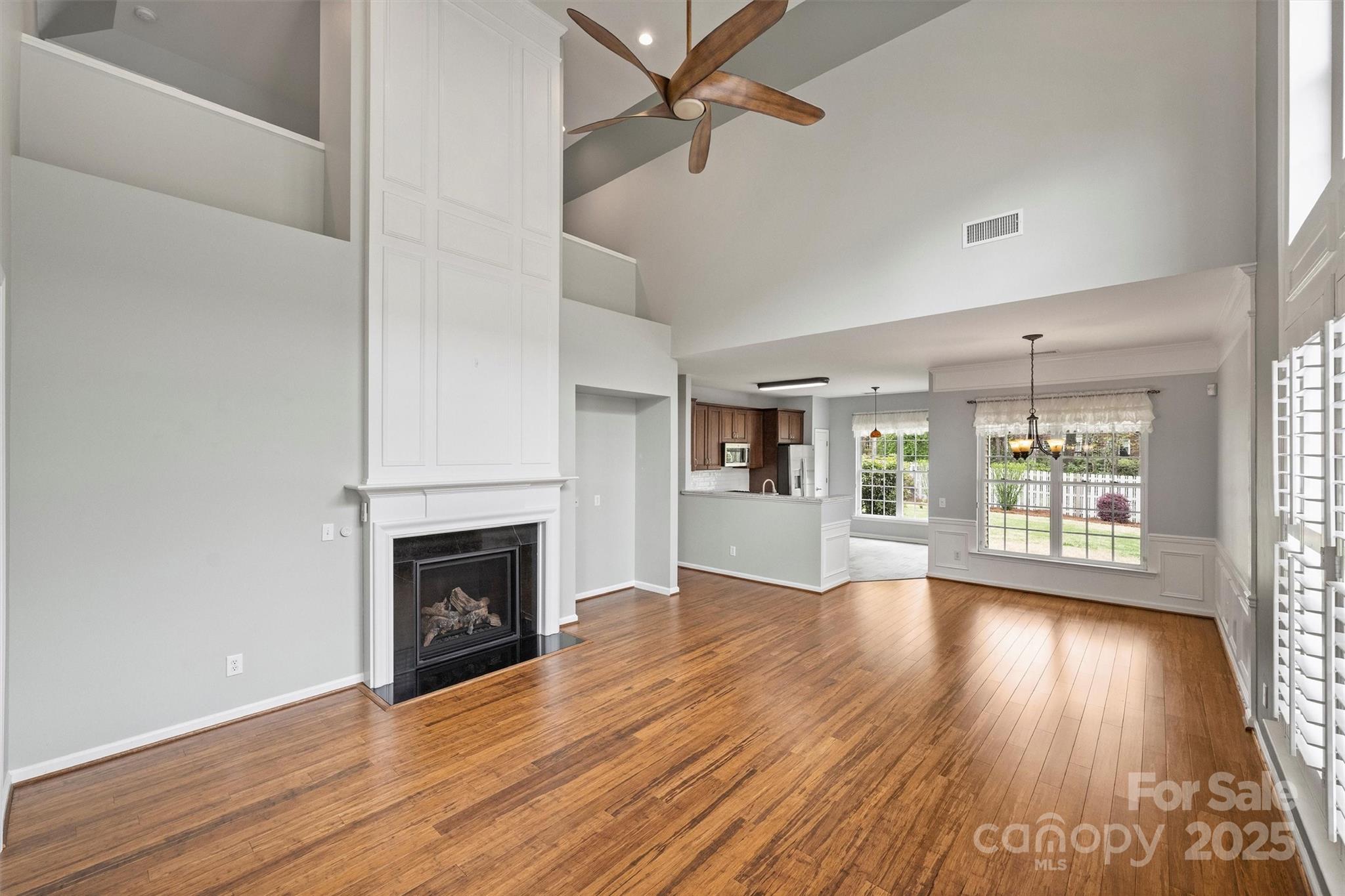 11422 Nevermore Way Charlotte, NC 28277 - Photo 5 of 34 an empty room with wooden floor fireplace and windows