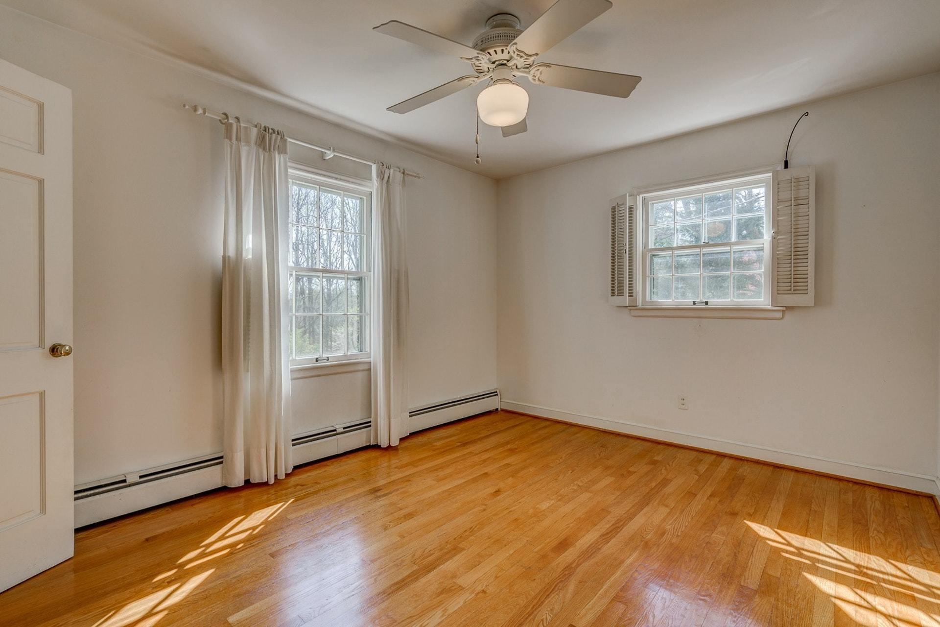 5571 Highfields Road Roanoke, VA 24018 - Photo 18 of 45 an empty room with wooden floor chandelier fan and windows