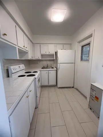 a kitchen with cabinets and white appliances