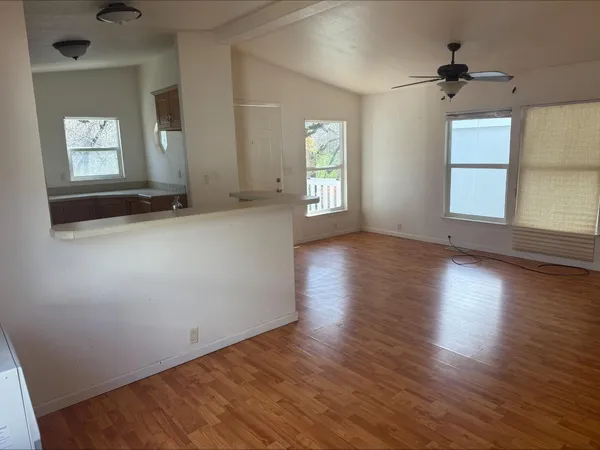 an empty room with wooden floor and windows