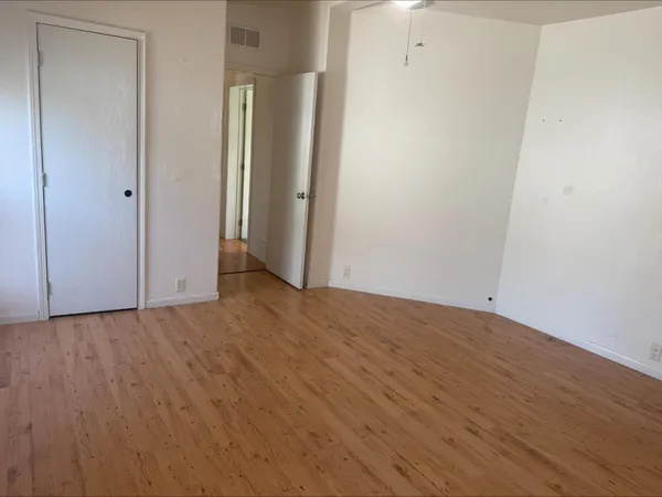 a view of an empty room with wooden floor