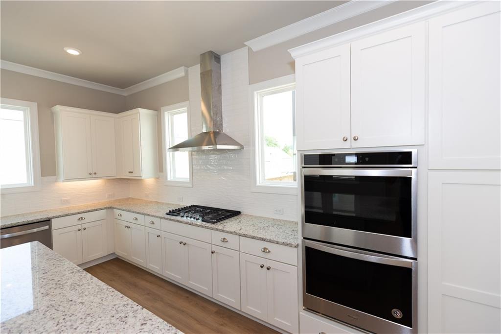 5590 Broad River View Peachtree Corners, GA 30092 - Photo 14 of 37 a kitchen with granite countertop white cabinets and appliances