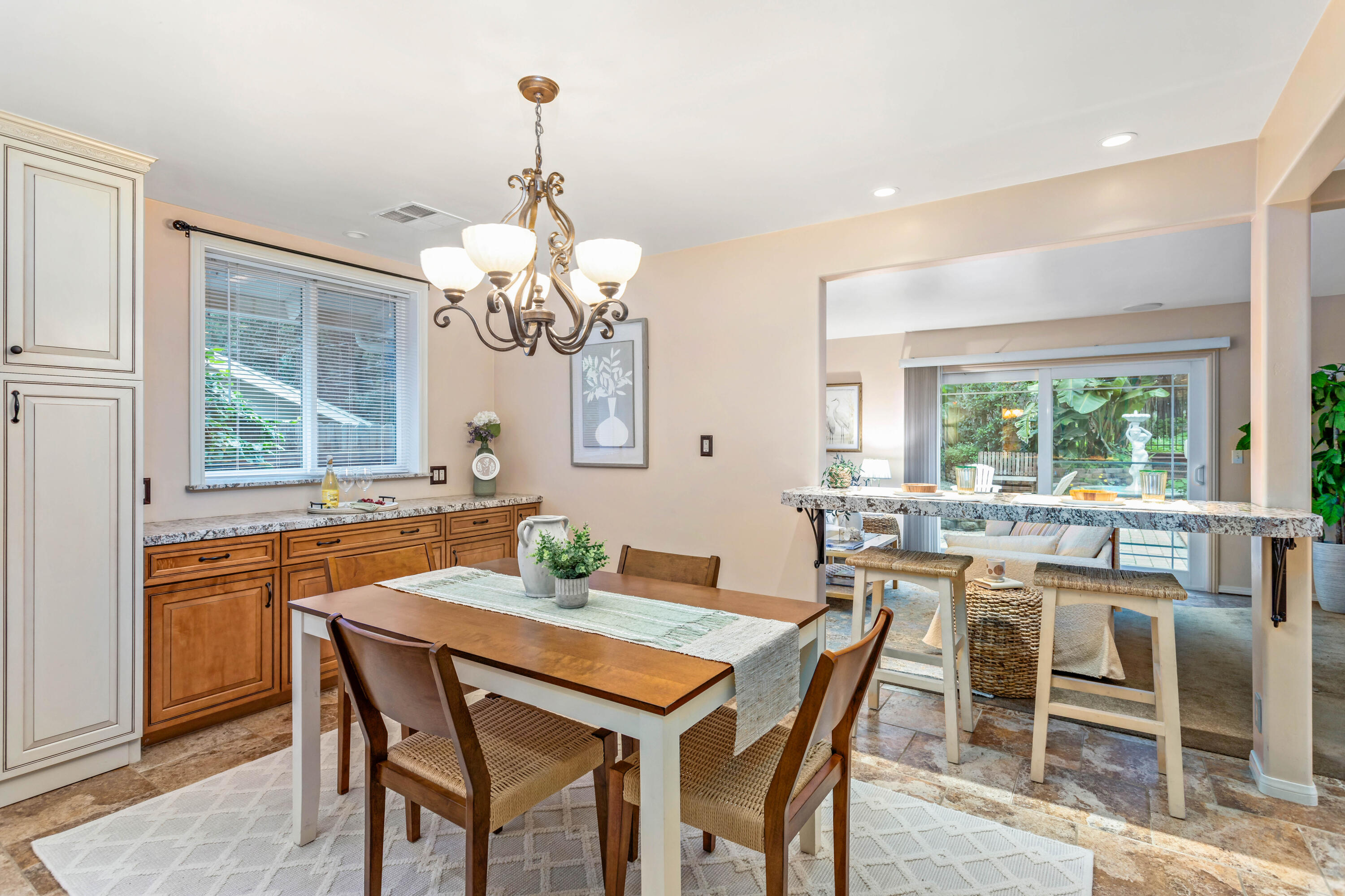 253 Pebble Beach Drive Goleta, CA 93117 - Photo 5 of 27 a dining room with wooden floor a chandelier a wooden table and chairs