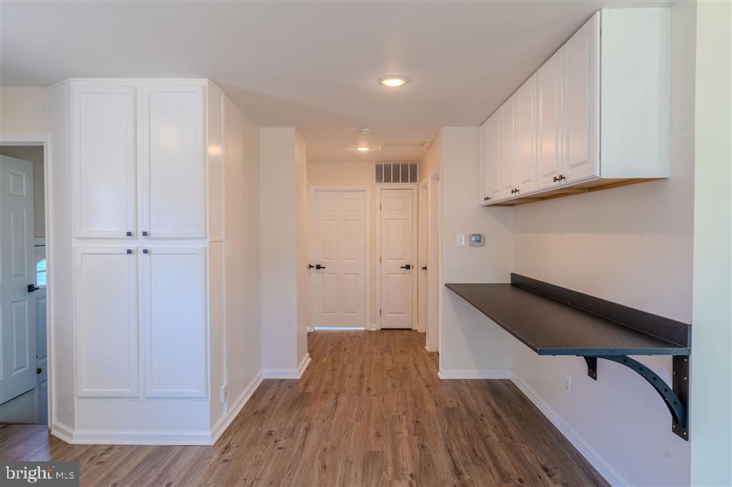 12324 Centerhill Street Silver Spring, MD 20902 - Photo 8 of 24 a hallway with wooden floor cabinets and staircase